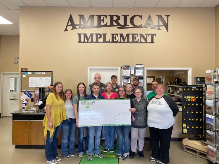 The FFA sponsor and robotics coach pose with six students and four employees of the American Implement.