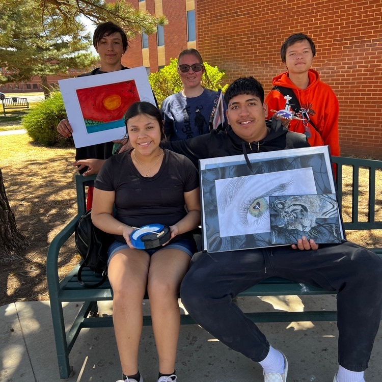 group photo of five students with their art on a bench
